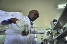 A man pouring liquid into a beaker in a lab