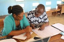 Project staff in Mtwara region, Tanzania, review monitoring data of insecticide-treated nets (ITNs).