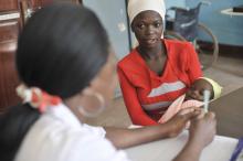 Nurse Pili Makota counsels pregnant Naima Omari, 19, with her daughter Nursery Juma, on how to use a bed net