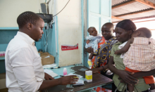 Pharmacist dispenses a prescription to two mothers with young children. Source – MSH Pharmacist dispenses a prescription to two mothers with young children.