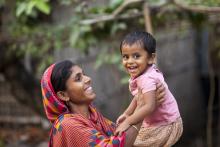 A woman holds her child. Source - SPRING/Bangladesh.  