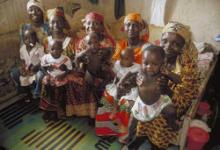 Group of mothers waiting with their children in the waiting room of a public health facility in Nigeria.