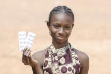 A girl holds up medication. Photo credit- iStock. A girl holds up medication. Photo credit- iStock.